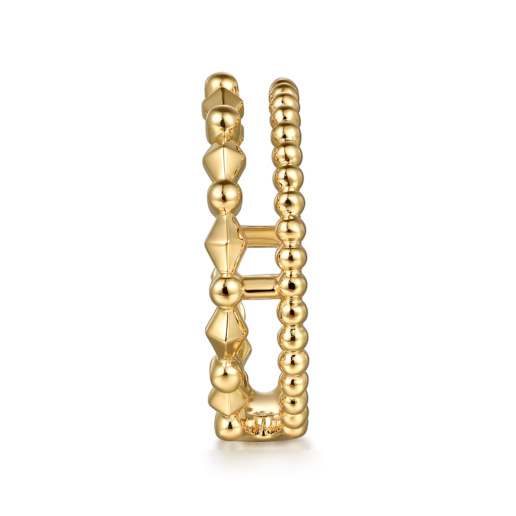 Gold ring with beaded design on a white background