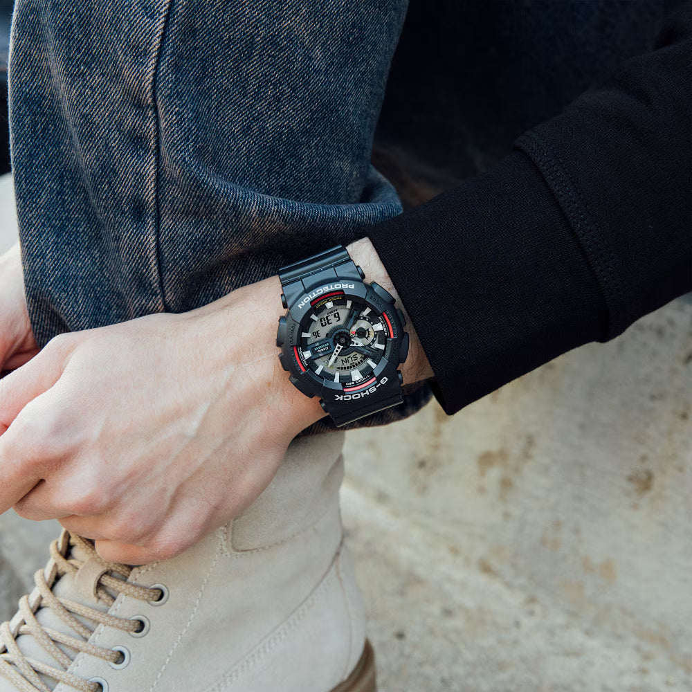 Person wearing a black digital watch on a blurred background