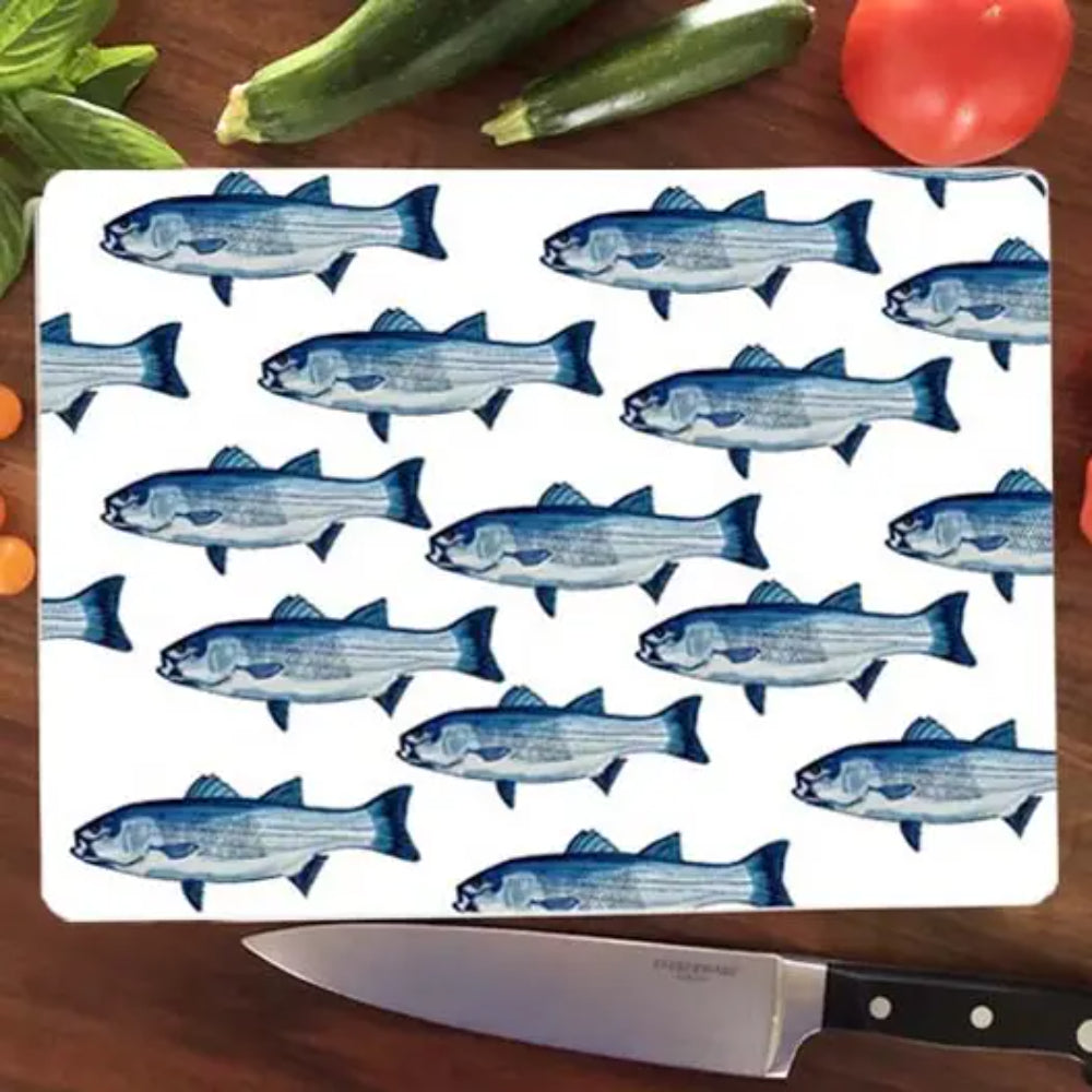 Cutting board with fish pattern on a wooden surface with vegetables