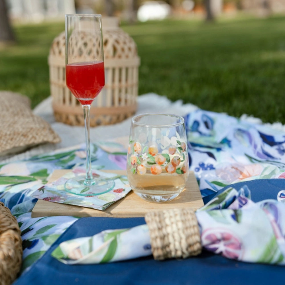 Outdoor picnic scene with drinks on a blanket