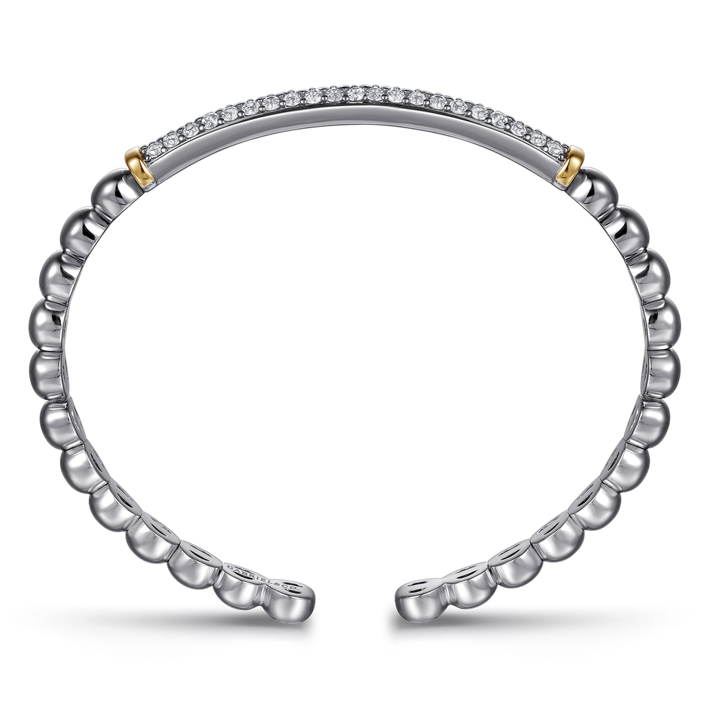 Silver bracelet with gold accents on a white background