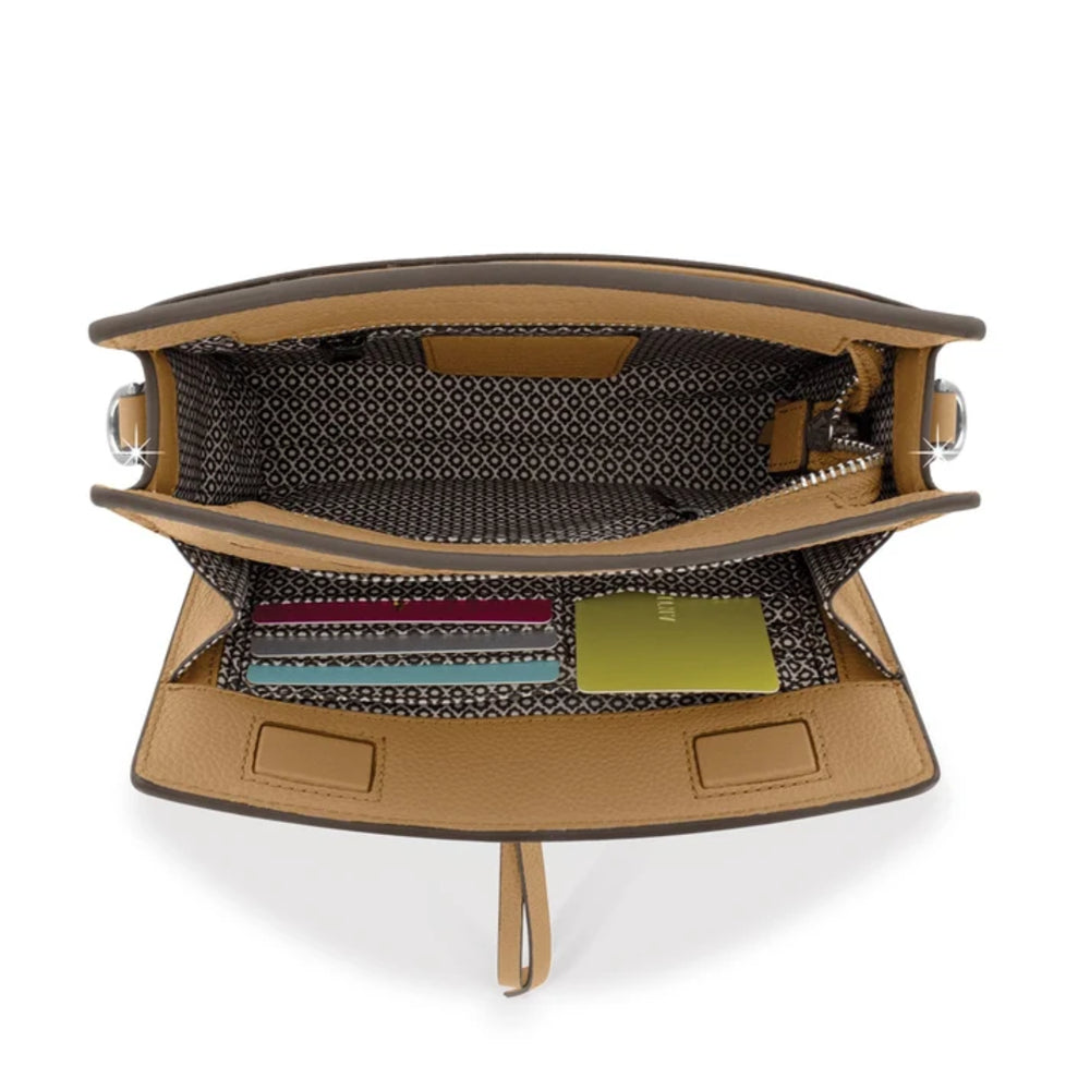 An open tan leather handbag shown from above, revealing a patterned black-and-white interior lining with card slots, a zip pocket, and a small green card inside.