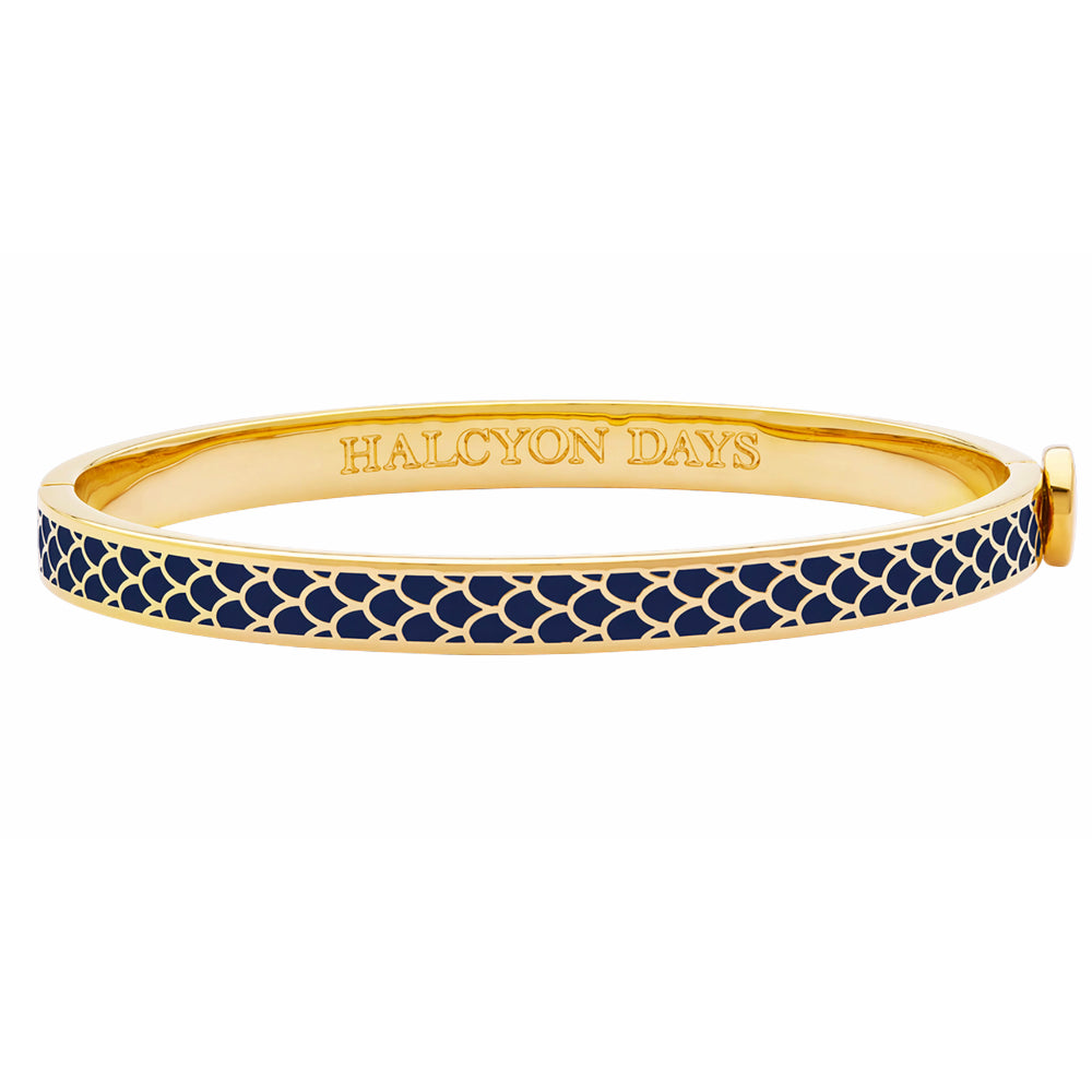 Gold bangle with navy pattern and 'HALCYON DAYS' engraving on a white background
