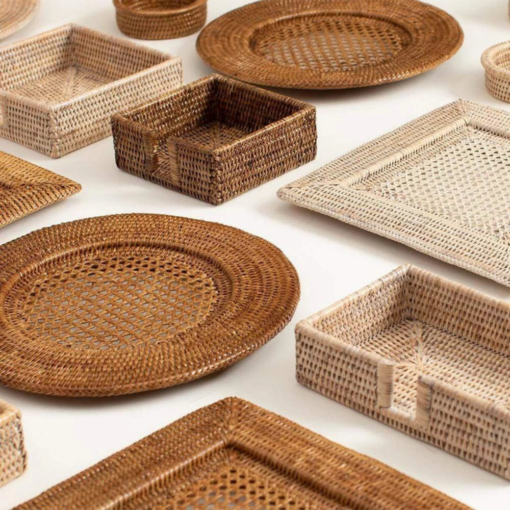 Collection of woven wicker trays and plates on a white background