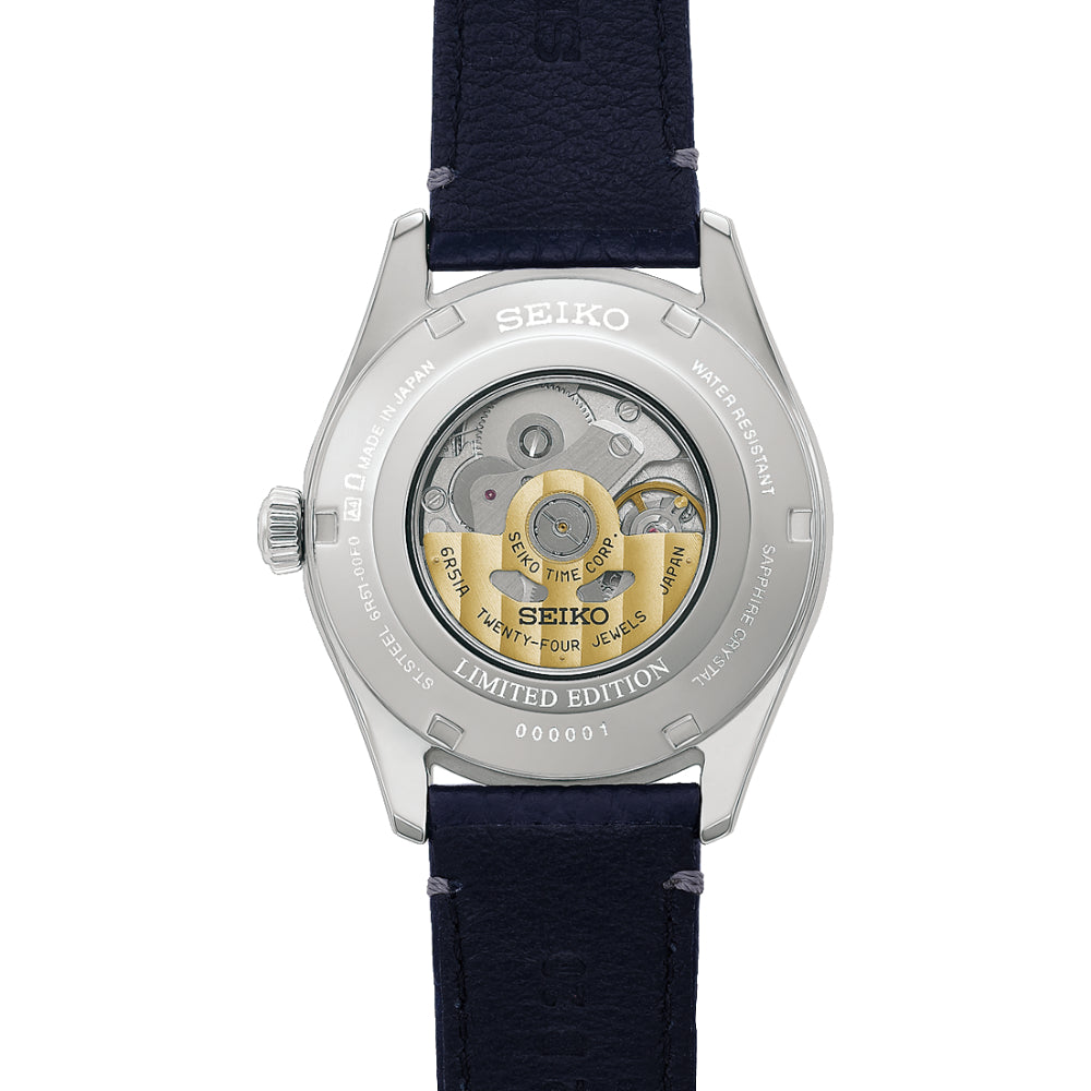 Seiko watch with blue strap and visible mechanical components on a white background