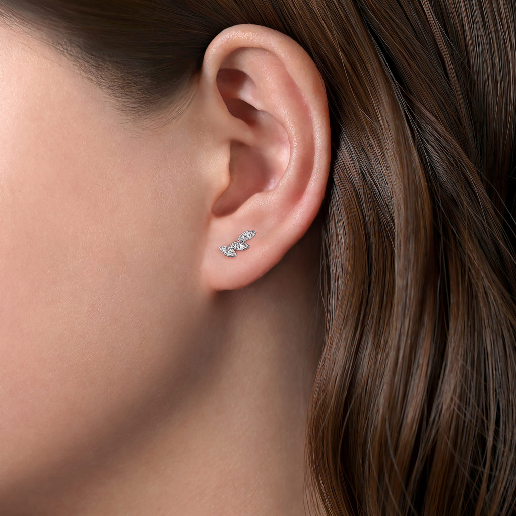 Close-up of a person wearing a gold hoop earring with brown hair.