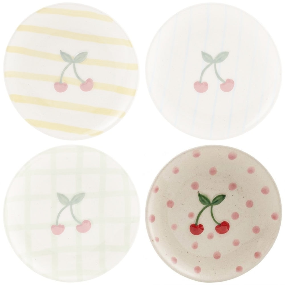 Ceramic plate with a cherry design on and pink dots on a white background.