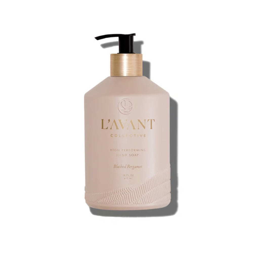 A bottle of L'Avant Collective Hand Soap in the Blush Bergamot scent, featuring a matte blush pink bottle with a gold metallic collar and a black pump dispenser, set against a plain white background with a soft shadow.
