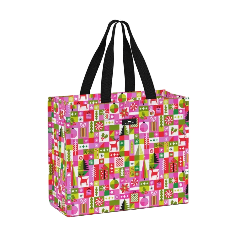 A reusable tote bag with a vibrant pink and green holiday-themed pattern featuring Christmas ornaments, candy canes, gifts, and trees, complete with black shoulder straps, shown on a light gray background.