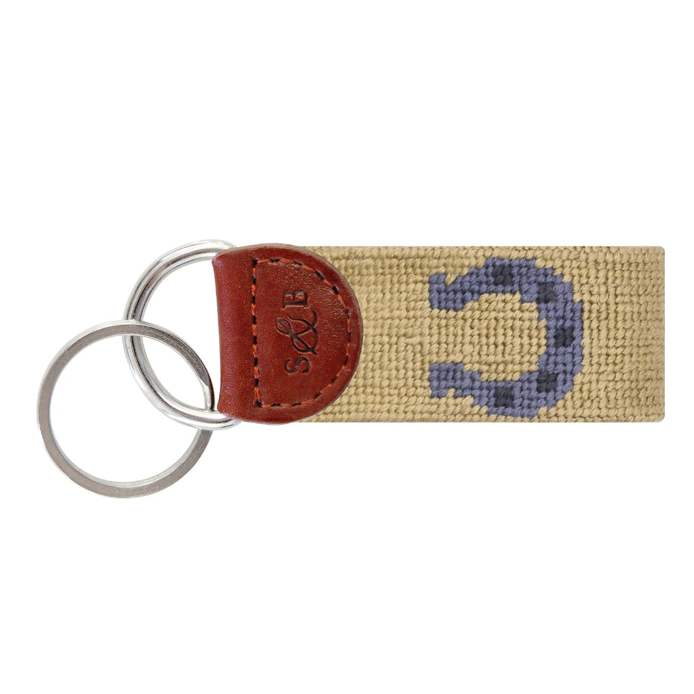 Key fob with beige color and blue horseshoe on white background.