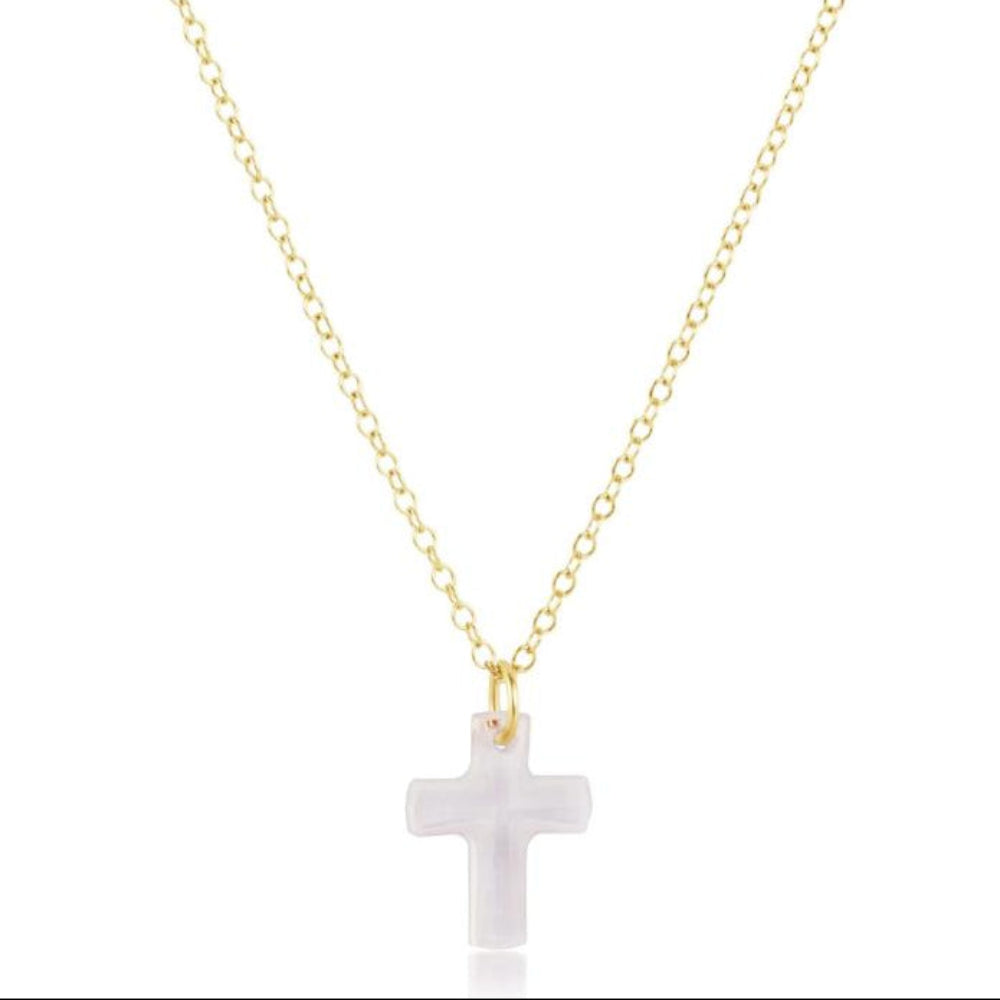 Gold necklace with a white cross pendant on a white background