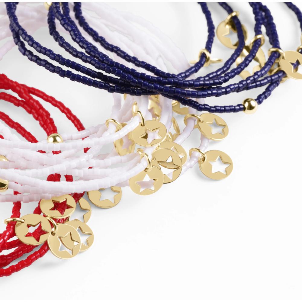 Bracelets with red, white, and blue strings and gold charm beads on a white background