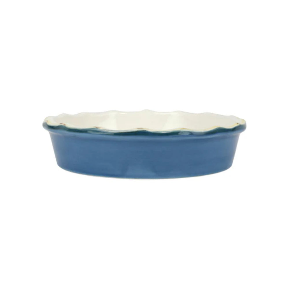 Blue ceramic dish with scalloped gold edge on a white background