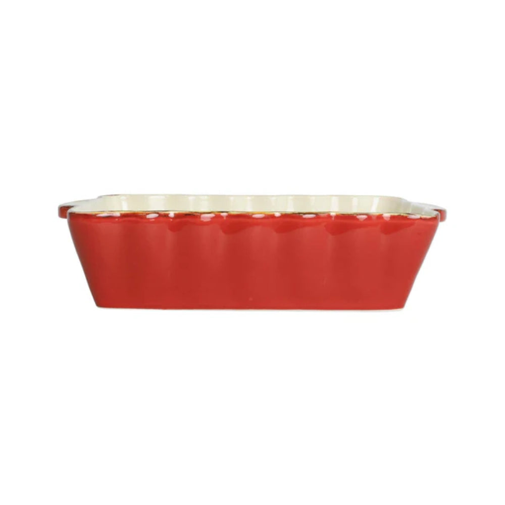 A medium red rectangular stoneware baker with scalloped edges and gold rim with a beige interior