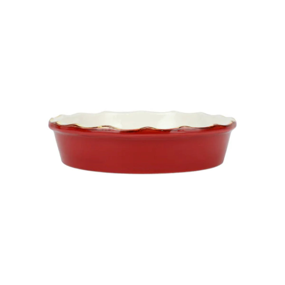 Red ceramic pie dish with scalloped gold edge on a white background