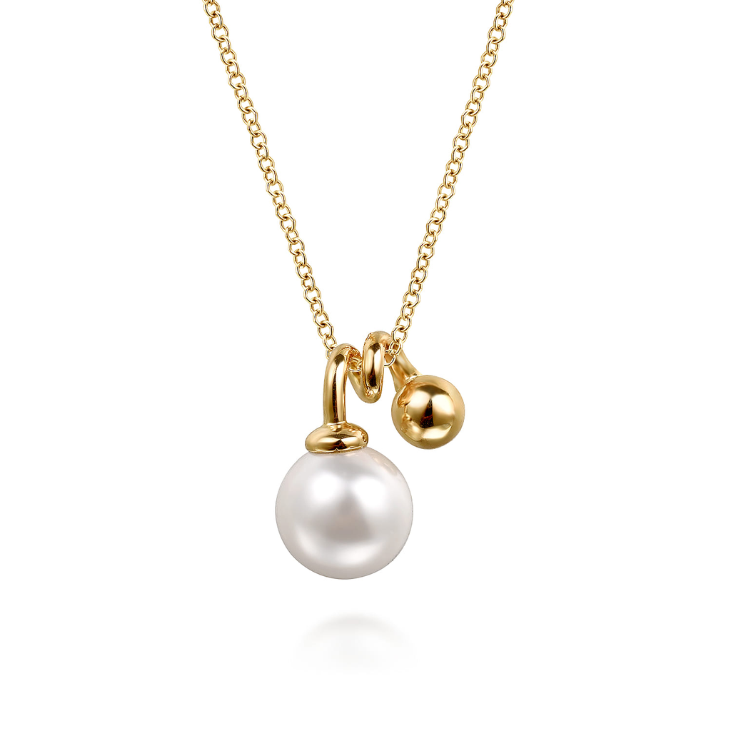 Pearl pendant on yellow gold chain on white background