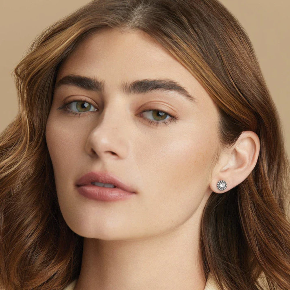 Close-up of a woman wearing earrings with a neutral background