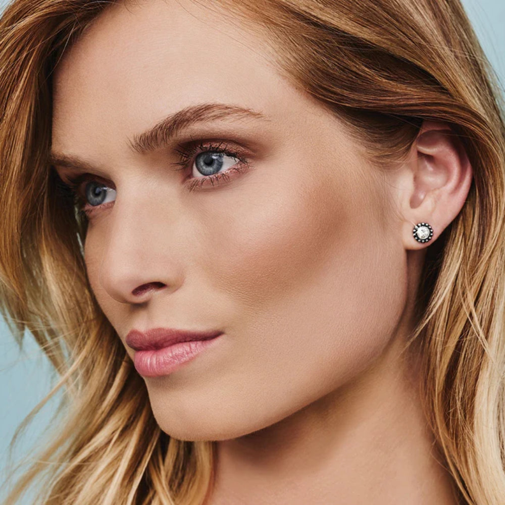 Close-up of a woman wearing earrings with a light blue background