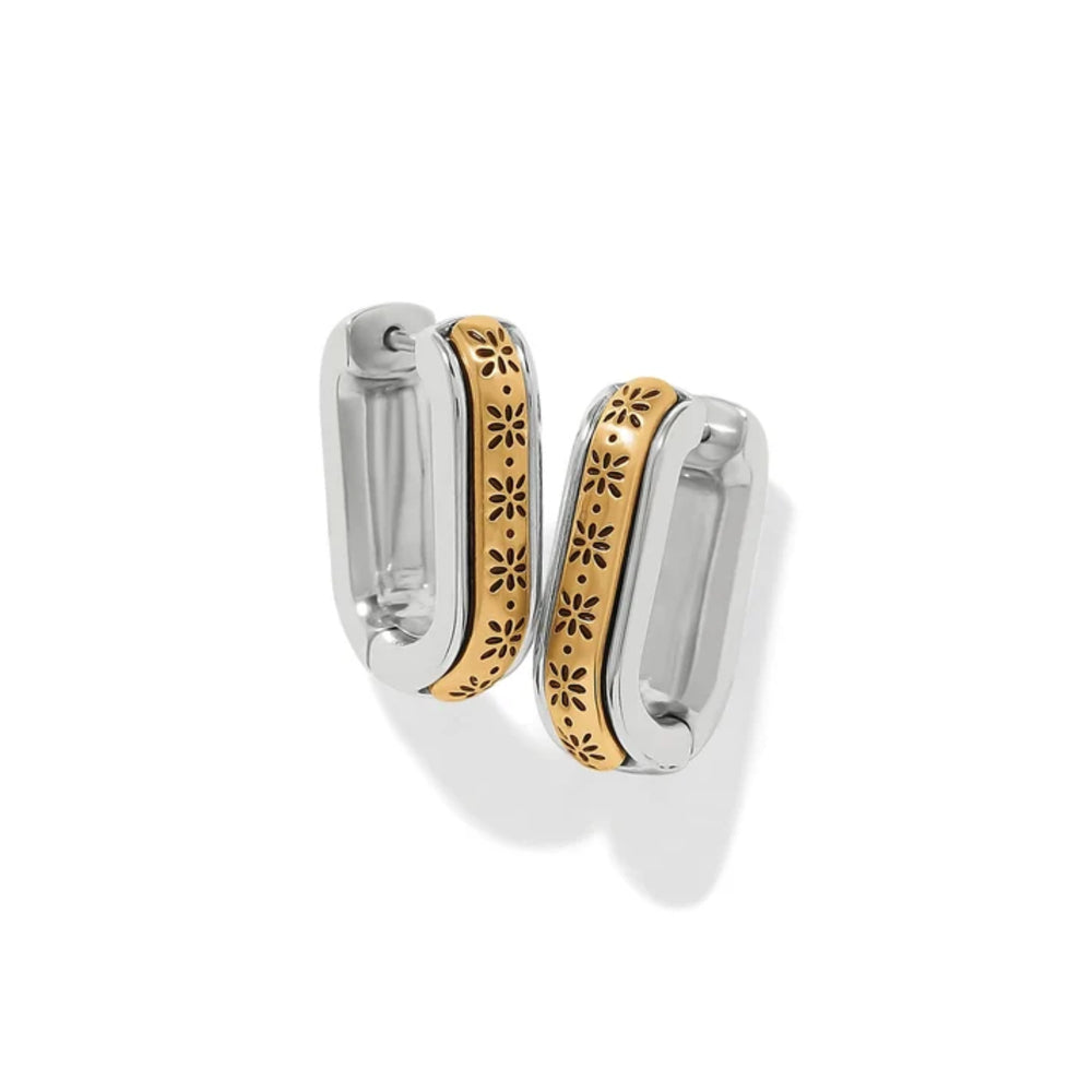 A pair of silver-toned hoop earrings with a central gold-toned band featuring a floral cutout pattern, shown on a clean white background.