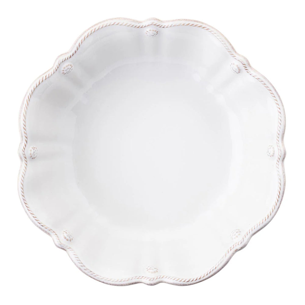 White scalloped plate with decorative edge on a white background