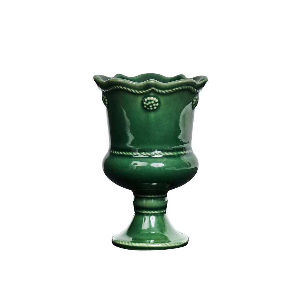 A glossy dark green ceramic pedestal vase with a scalloped rim and decorative raised details, shown on a plain white background.