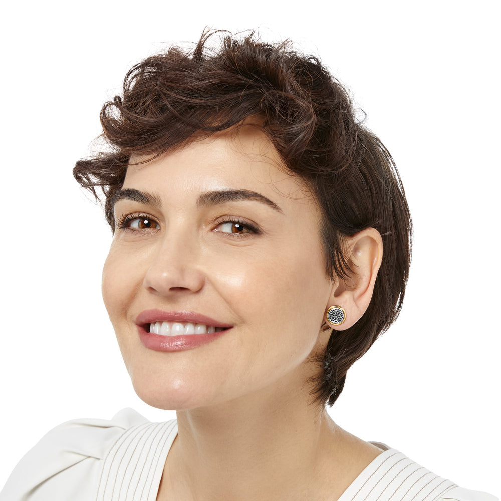 Woman with short dark hair wearing earrings on a white background