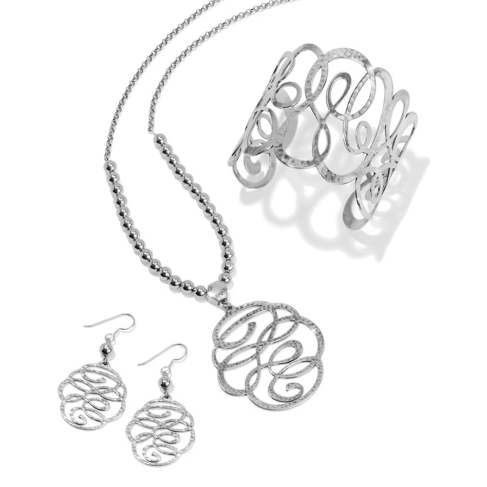 Silver monogrammed necklace, bracelet, and earrings on a white background