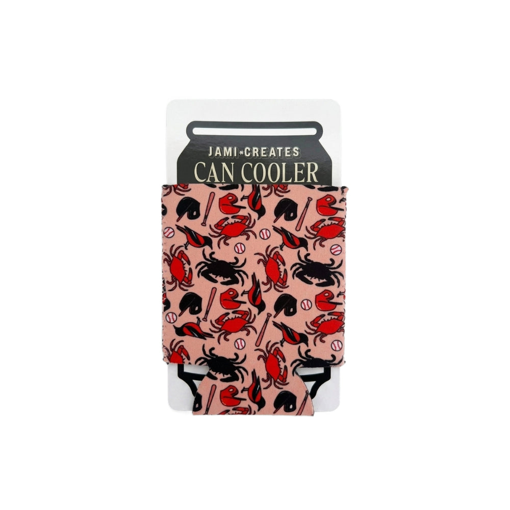 A Jami-Creates can cooler sleeve with a pink background and a black and red crab pattern, shown on its white retail card packaging against a white background.