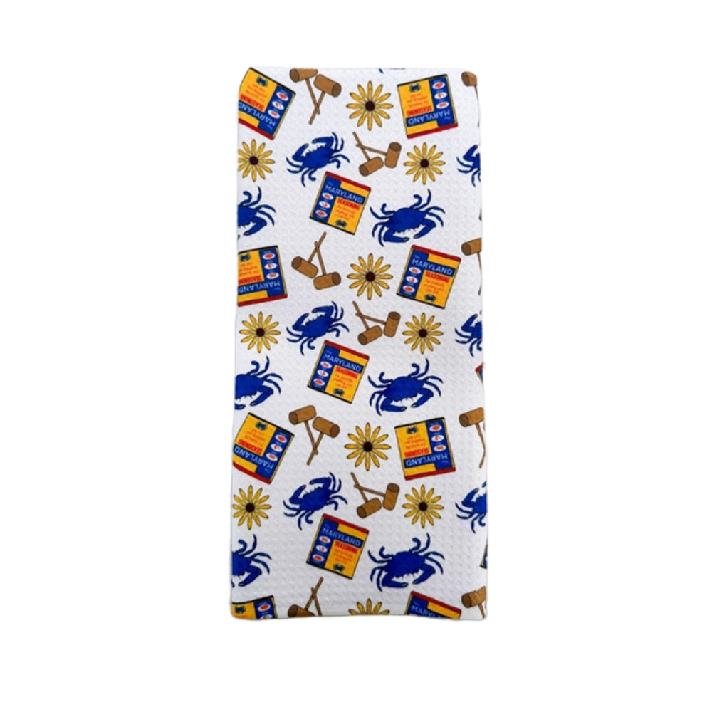 Folded towel with blue crab and yellow sunflower pattern on a white background