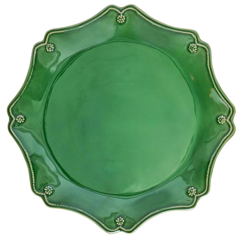 A green ceramic plate with a scalloped rim and small decorative raised dots around the edge, shown on a plain white background.