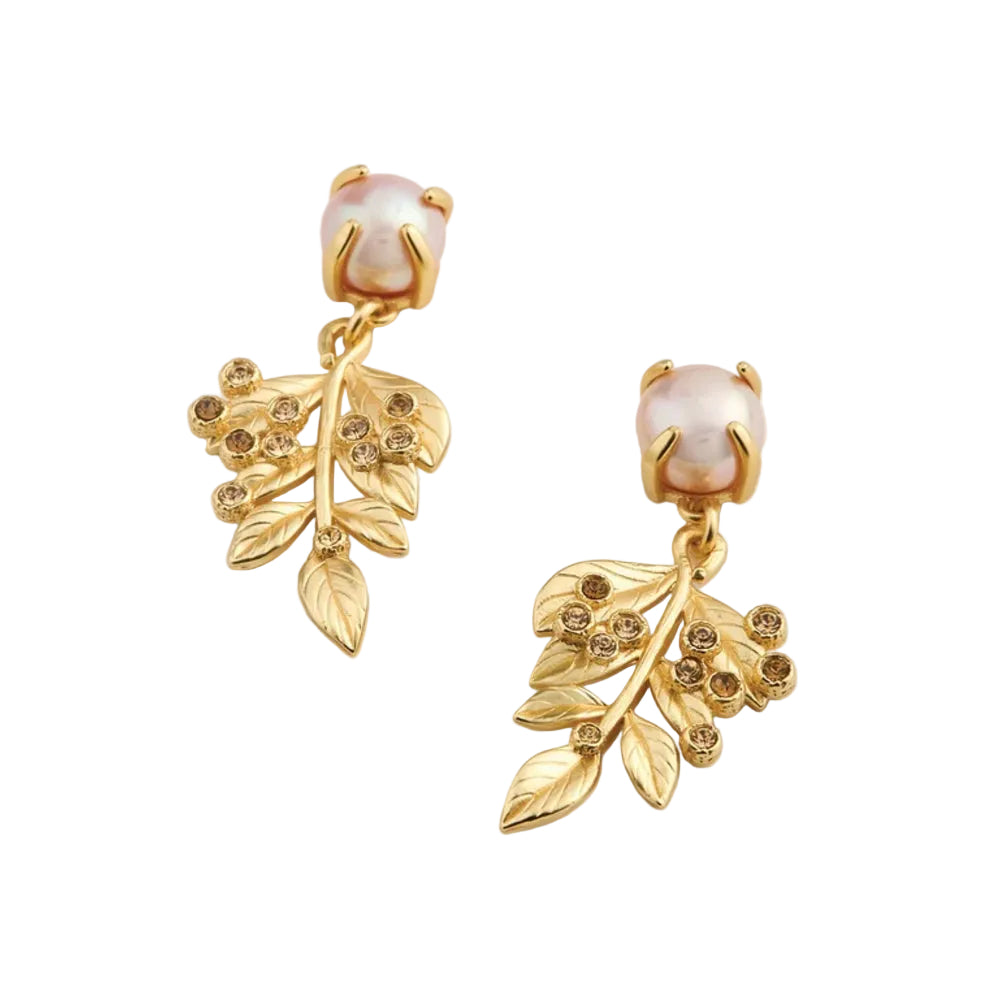 A pair of gold dangle earrings featuring leafy branches adorned with small clear rhinestones and a round, lustrous pale pink pearl at the top, displayed on a clean off-white background.