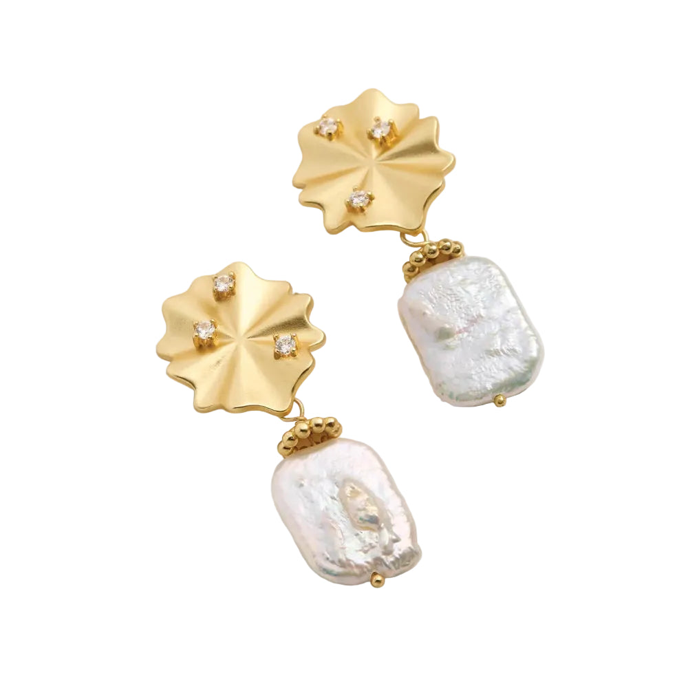 A pair of gold drop earrings featuring textured gold flower-shaped studs with small clear rhinestones and irregular white baroque pearl drops, displayed on a white background.