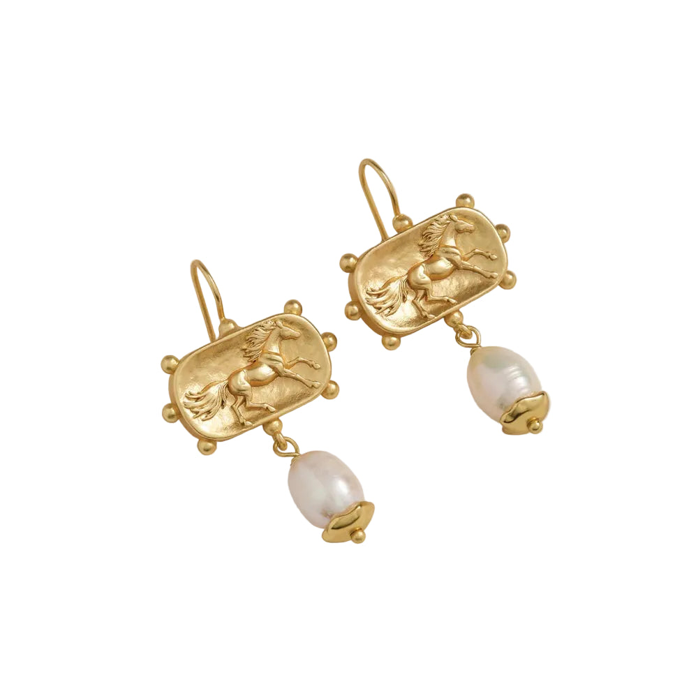 A pair of gold drop earrings featuring an engraved rectangular plaque with a horse motif and a dangling baroque pearl bead, shown on a white background.