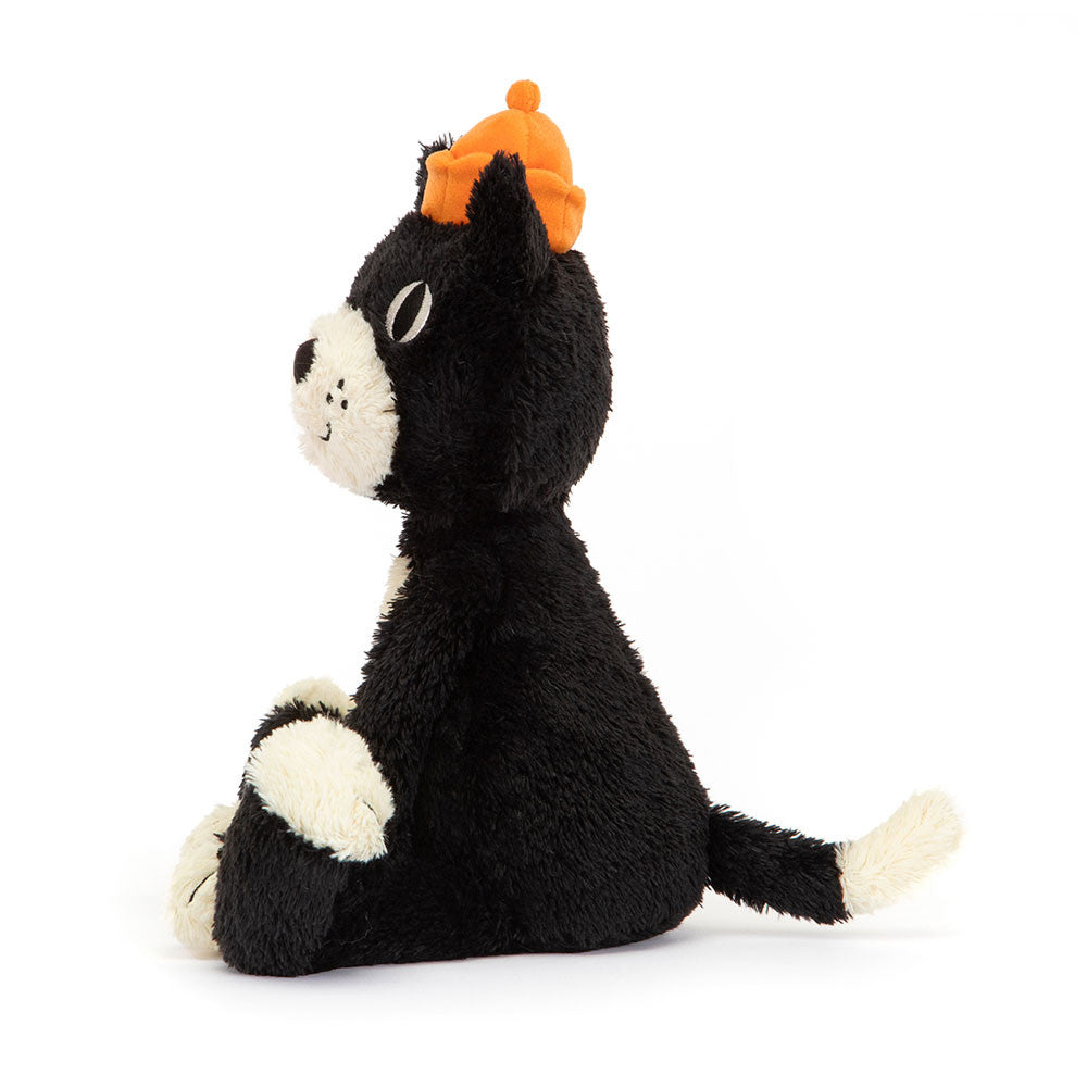 A side photo of a plush tuxedo cat with a black and white fur, orange stitched paws, and a velour crown.