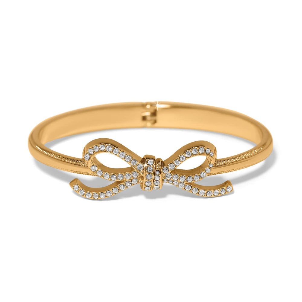 A gold bangle bracelet featuring a central bow design paved with small clear stones, shown on a clean white background.