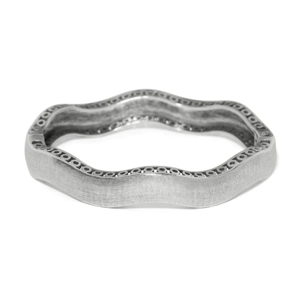 Silver bangle with wavy design on a white background