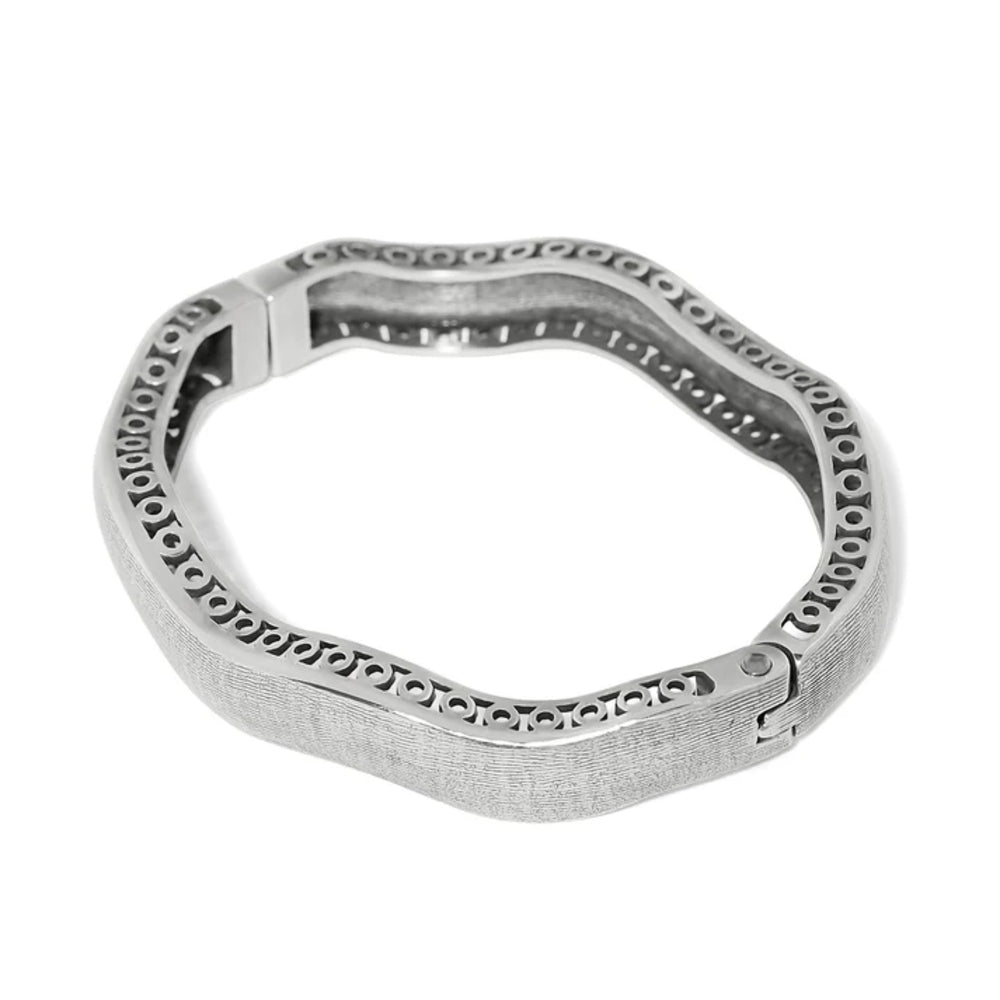 A textured silver-toned metal bangle bracelet with a wavy, organic shape and a repeating circular cutout pattern along the outer edge, shown on a plain white background.