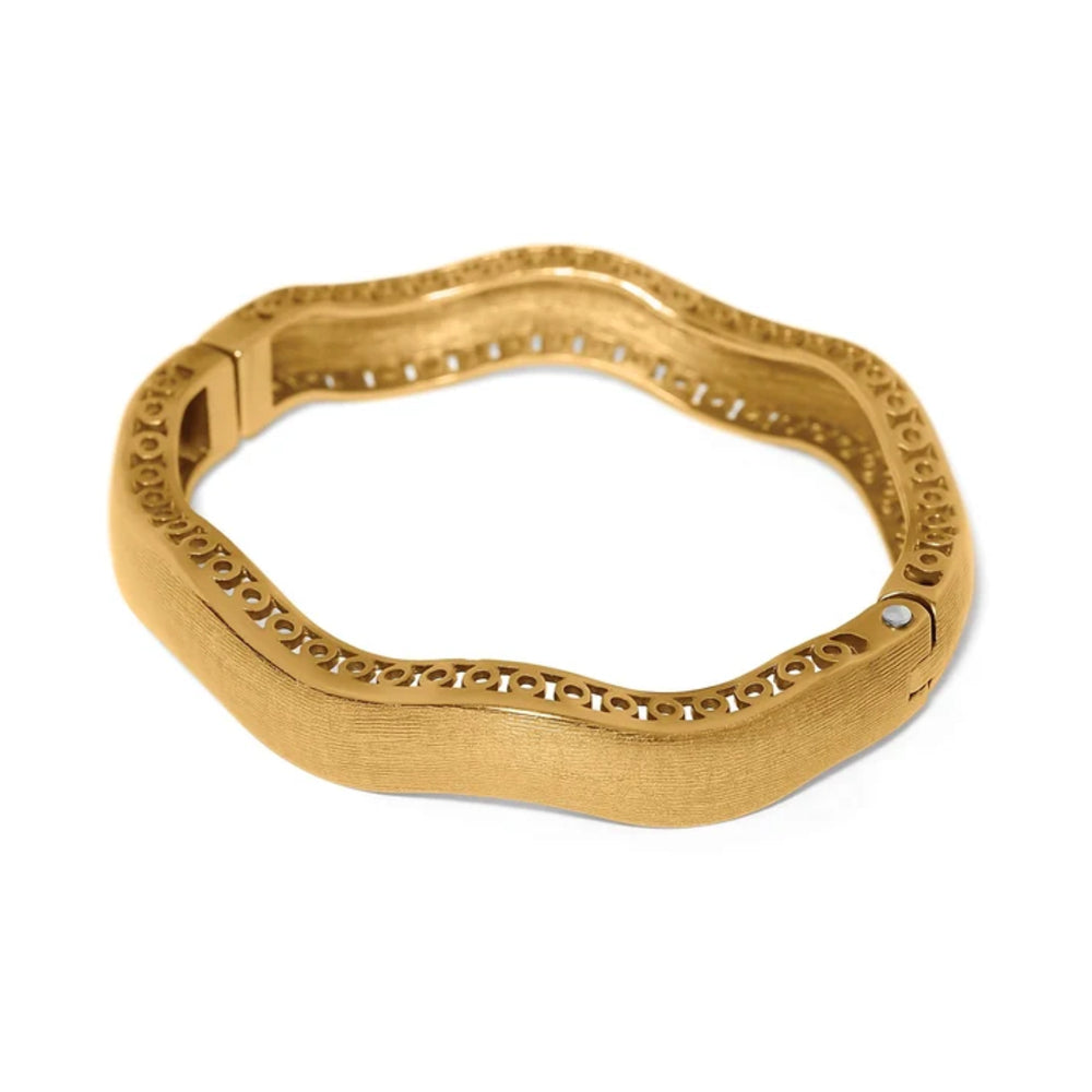 A textured gold bangle bracelet with a wavy, organic shape and a decorative cutout pattern along the inner edge, shown on a plain white background.