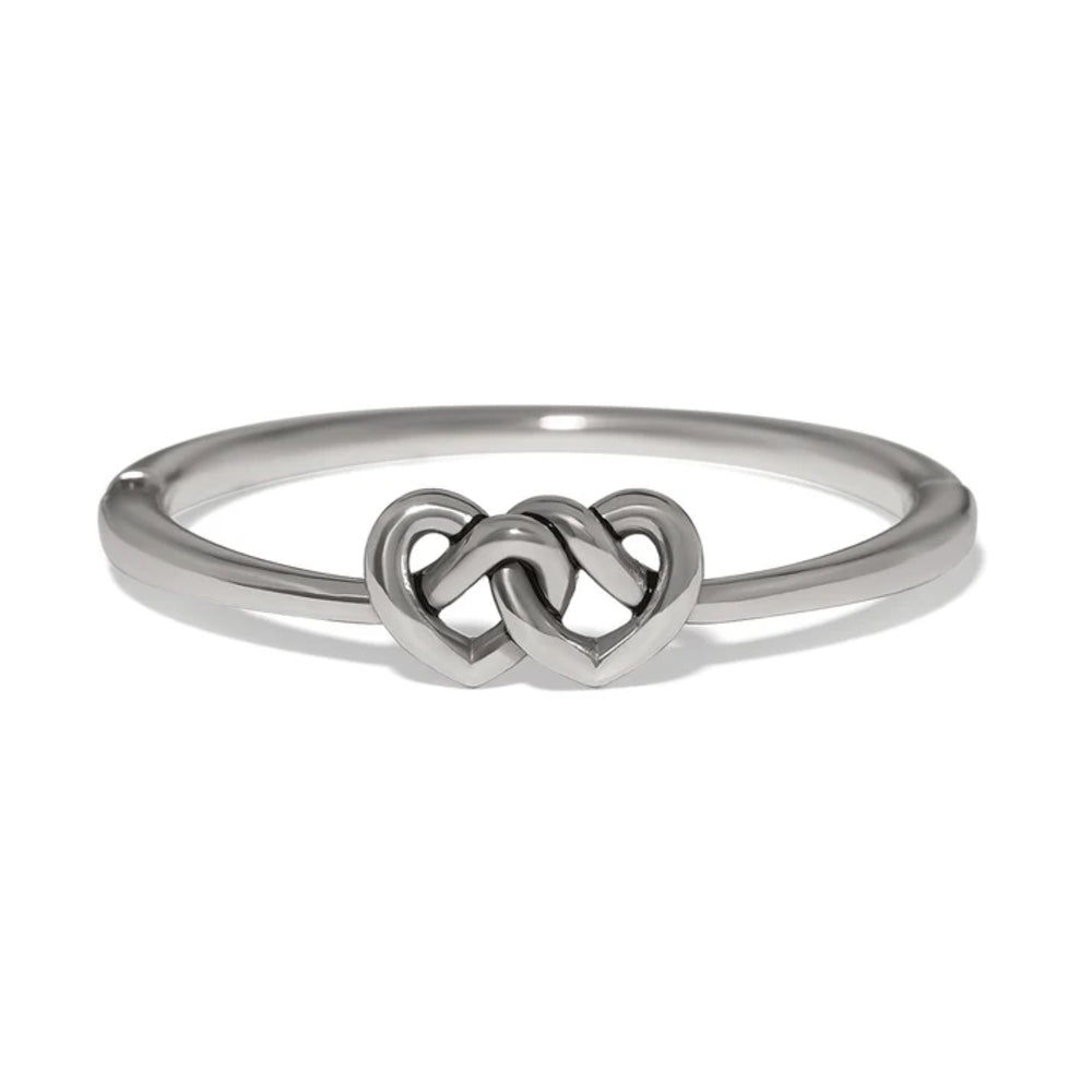 A polished silver bangle featuring a central interlocking double heart design, shown on a clean white background.