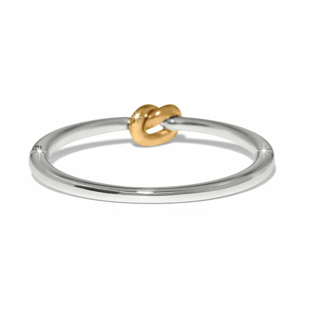 A minimalist two-tone ring featuring a polished silver band and a small gold knot detail at the center, set against a clean white background.
