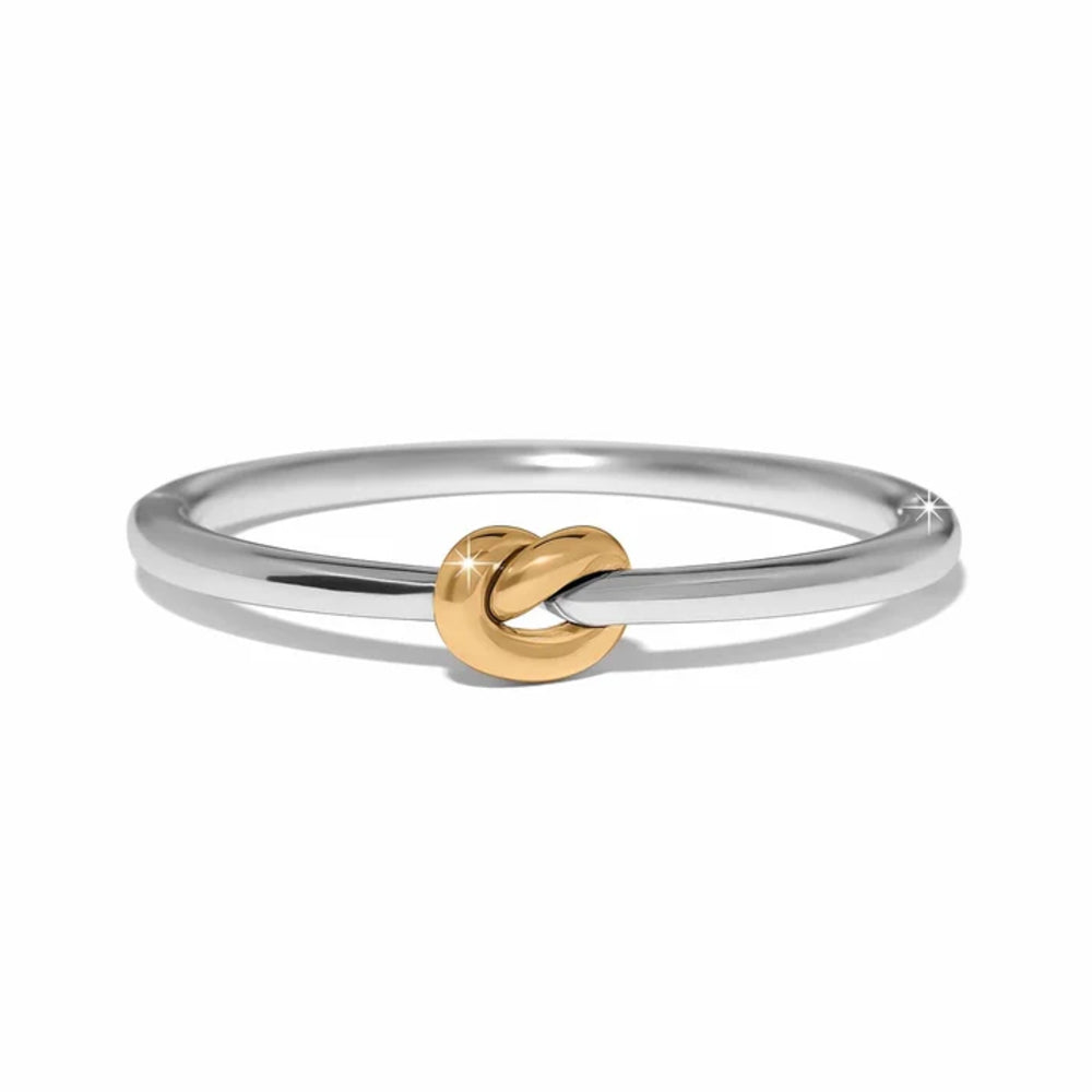 A minimalist two-tone ring featuring a polished silver band with a central gold knot accent, set against a clean white background.