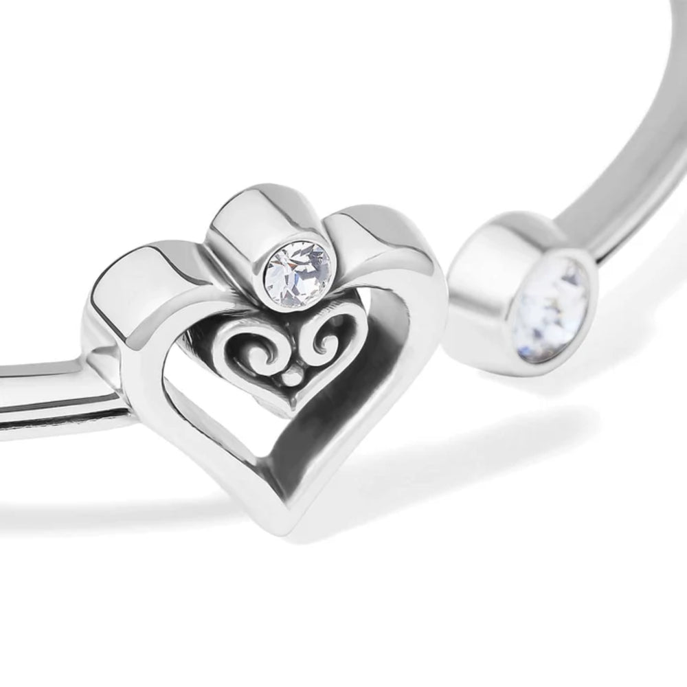 Silver heart-shaped bracelet with a clear gemstone on a white background
