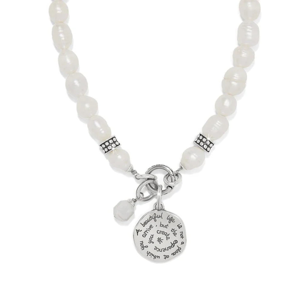 Pearl necklace with a silver charm on a white background