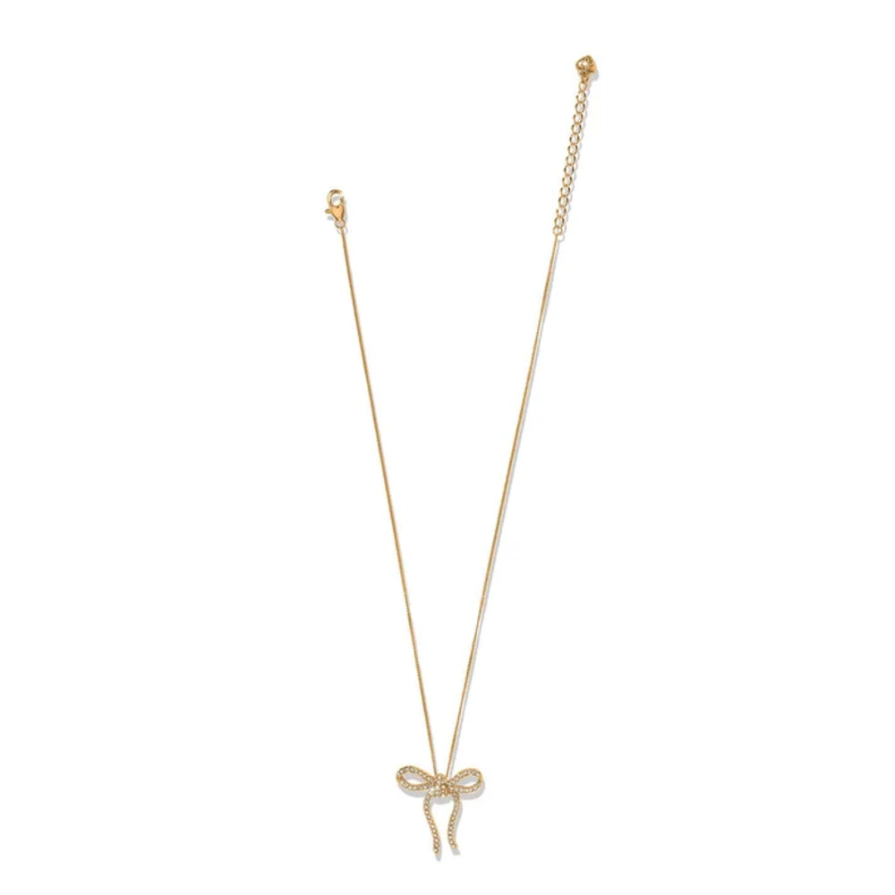 A delicate gold chain necklace featuring a small bow-shaped pendant adorned with clear pavé stones, displayed against a solid white background.