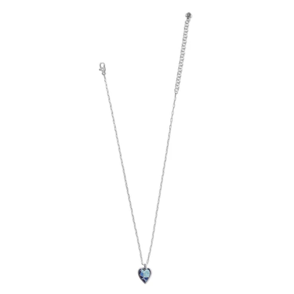 A delicate silver-toned chain necklace with a small heart-shaped pendant featuring a light blue center, displayed against a solid white background.