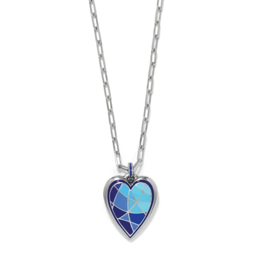 A silver heart-shaped pendant necklace featuring a mosaic design of light blue, medium blue, and navy enamel sections, suspended from a silver link chain on a white background.