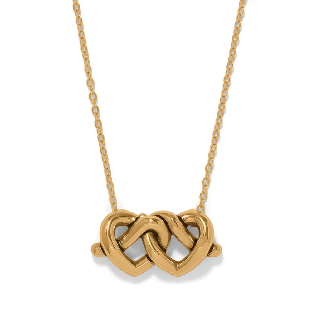 A gold necklace featuring two interlocking hearts in a polished openwork pendant, suspended from a delicate gold chain against a plain white background.