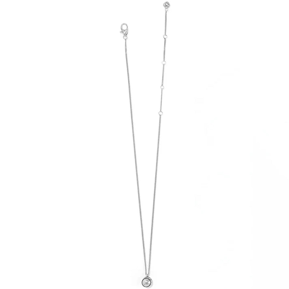A delicate silver chain necklace with a small circular pendant, displayed vertically against a plain white background.
