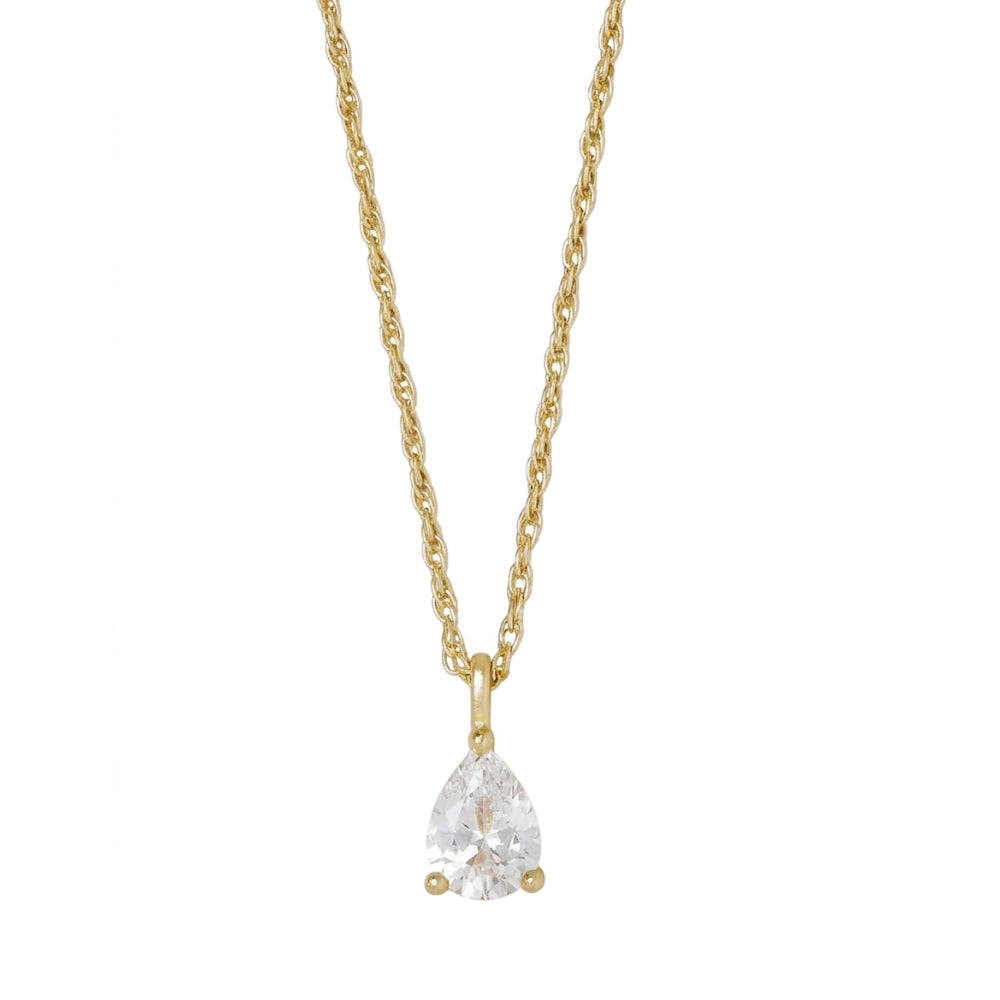A gold necklace with a pear-cut clear gemstone pendant in a three-prong setting, suspended from a delicate gold chain against a plain white background.