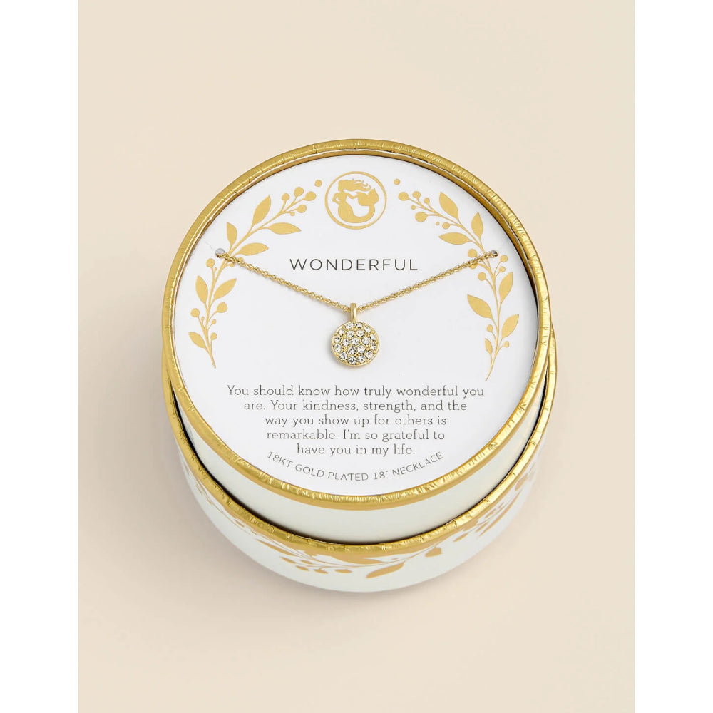 A round white and gold jewelry gift box with a small gold necklace displayed on a printed card inside. The card reads 'WONDERFUL' and includes a message, with the necklace pendant visible at the center.